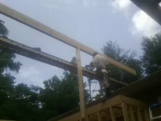 Carpenter setting a ridge beam over a new addition frame — Ice Dam Removal by Roofing Brothers in Elkhorn City