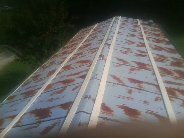 Rusted metal roof panels with new wood purlins before replacement — Storm Damage Roof Repair in Elkhorn City by Roofing Brothers