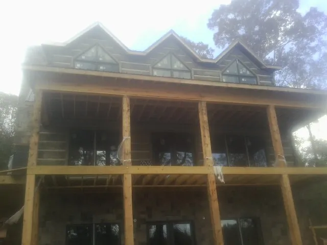 Dormers and porch framing on a large log home under construction — Roof Coating work by our crew in Elkhorn City