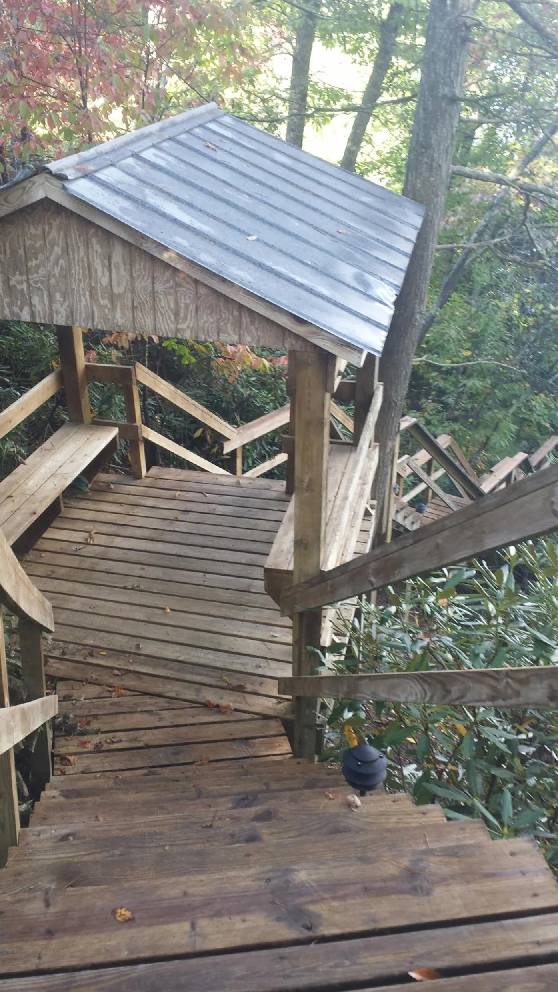 Metal roofed shelter over wooden steps on a wooded walkway — Skylight Repair & Installation work by our crew in Elkhorn City