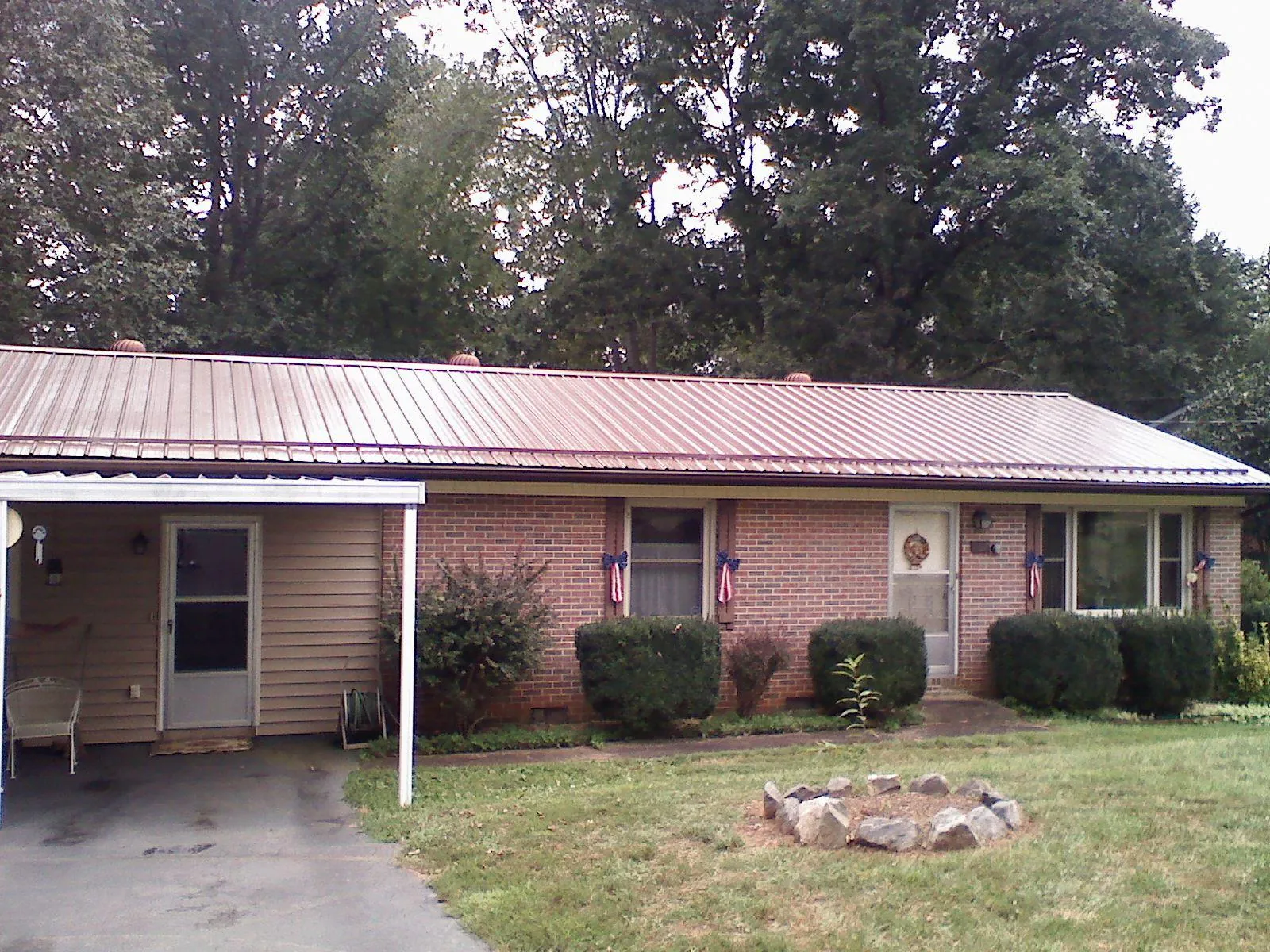 Bronze metal roof and carport on a brick ranch home — Roof Repair work by our crew in Elkhorn City
