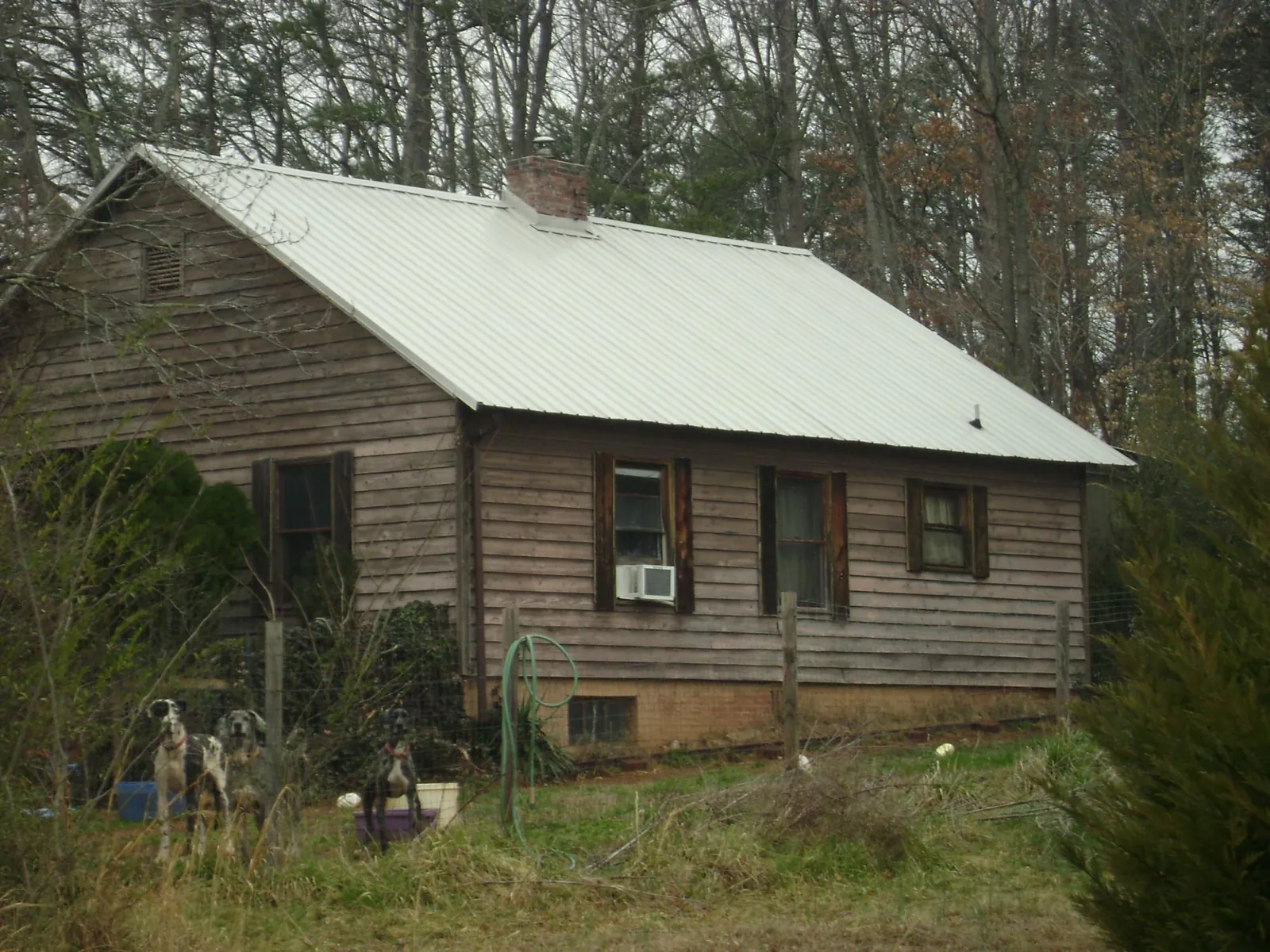 White metal roof on an old wood sided farmhouse, from a Metal Roof Installation job in Elkhorn City